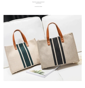 Close-up of canvas tote bags with leather handles and stripes on a white sofa