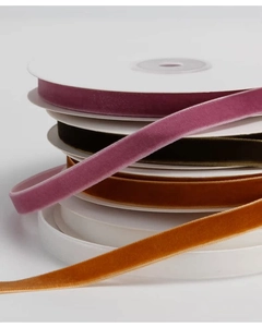 Close-up of 9mm velvet ribbons in multiple colors on white plastic spools for DIY crafts