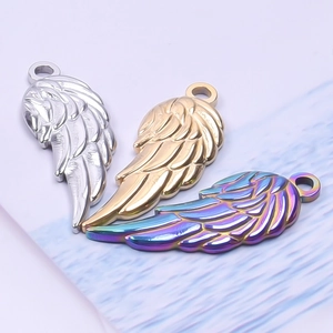 Detailed view of wing-shaped stainless steel pendants in silver, gold and rainbow colors