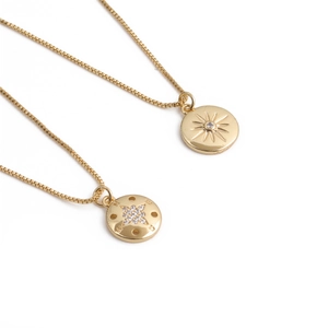 Détail des pendentifs boussole et étoile à huit branches dorés avec incrustations de diamants