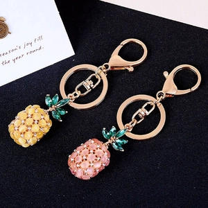 Close-up of pineapple keychains with opal beads, green crystals and gold lobster clasp