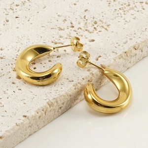 18K gold plated C-shaped stainless steel hoop earrings on a textured stone display