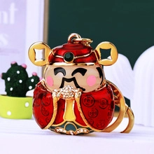 Detail of red and gold God of Wealth keychain with rhinestone and enamel finish