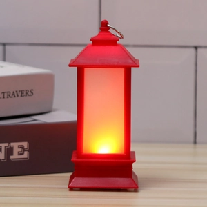 Close-up of red Christmas LED lantern with warm candle flame effect and metal hanging ring