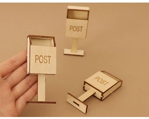 Detailed view of three miniature wooden dollhouse mailboxes with POST engraving