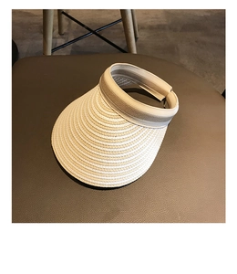 Detailed view of woven straw sun visor texture and striped design on leather background