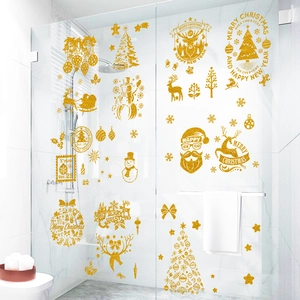 Close-up of golden glitter Santa and reindeer stickers applied on glass shower door