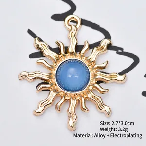 Detailed view of a 2.7x3.0cm golden sunburst alloy charm with a blue translucent bead
