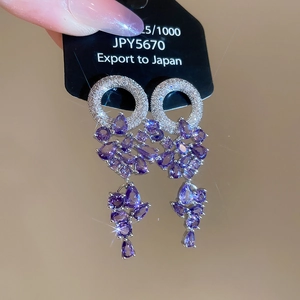 Détail de boucles d'oreilles en argent 925 avec zircons violets et gouttes en cristal