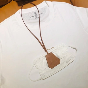 Close-up of brown litchi pattern leather lanyard for hats and masks on a white shirt