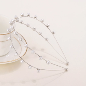 Elegant double-layered silver headband featuring minimalist white pearls on a beige backdrop