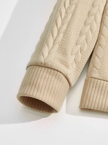 Close-up of beige quilted knit texture and ribbed cuff on a casual men's sweatshirt