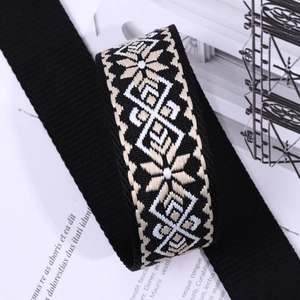 Close-up of ethnic style embroidered fabric bag strap in black and beige patterns