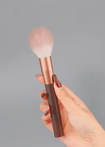 Detail view of pink loose powder brush with rose gold ferrule and ergonomic handle