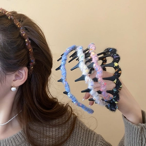 Close-up of knit wave hair comb headband featuring textured colorful wool yarn finish