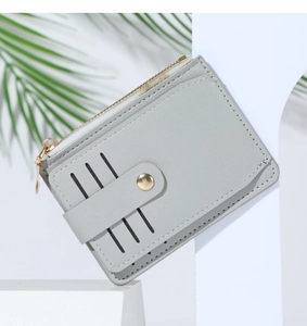 Detail of light grey PU leather card holder with four slots and golden metal snap button