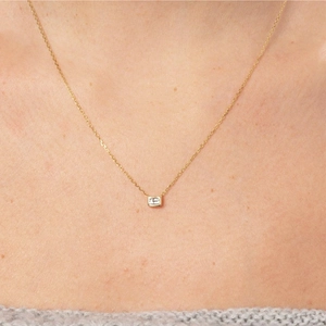 Close-up of minimalist gold-plated necklace with a square cubic zirconia pendant