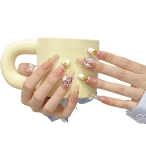 Handmade press-on nails with pink gradient French tips, 3D flowers, and luxury crystal studs