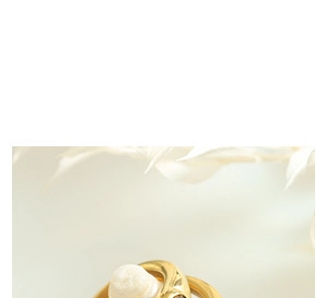 Close-up of gold-plated triple-layered snake coil bracelet with pearl detail