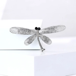 Detailed macro view of dragonfly brooch with silver alloy wings and white rhinestones