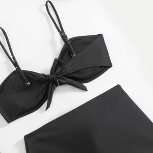 Detail of black three-piece bikini set with front bow tie and high waist design