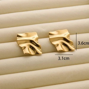 Macro detail of gold wave earrings with 3.1cm width and 3.6cm height measurements