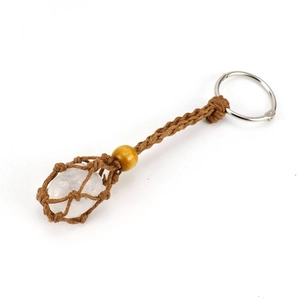 Detailed macro view of a handmade woven net keychain holding a natural clear crystal stone