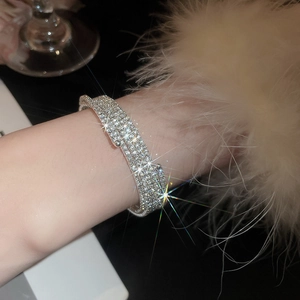 Dettaglio del bracciale elastico multistrato con strass lucidi e perle artificiali