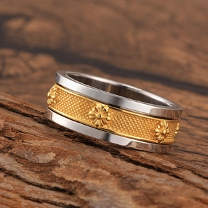 Macro detail of s925 silver and gold two-tone wide ring with floral embossed patterns