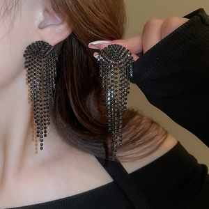 Close-up of long black rhinestone tassel earrings showing elegant cascading drop movement