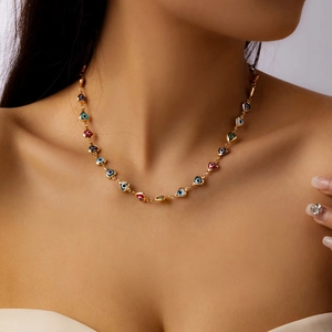 Close-up of golden beaded necklace with colorful evil eye heart pendants on a model