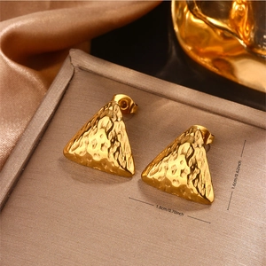 Makroaufnahme goldener strukturierter Dreiecksohrringe 1.8x1.6cm auf Seidenstoff