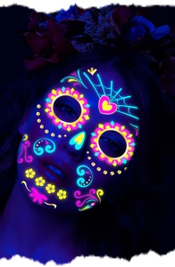 Neon Day of the Dead face tattoos glowing in the dark with floral sugar skull designs