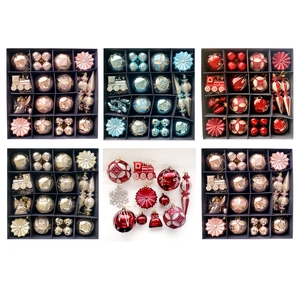 Verschiedene Weihnachtskugeln in Rosa, Gold und Blau in Form von Zügen, Sternen und Kugeln