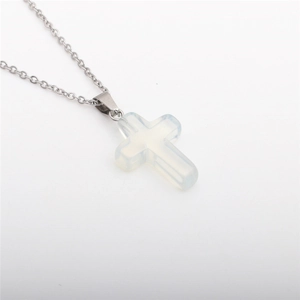 Detail of cross pendant necklace with white semi-precious stone on stainless steel chain