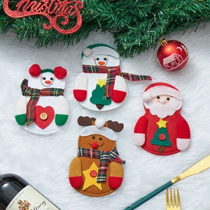 Weihnachts-Besteckhalter mit Weihnachtsmann, Schneemann und Rentier auf festlichem Tisch