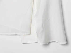 Close-up of white cotton linen shirt showing breathable texture and clean seam details
