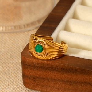 French vintage gold open ring with green stone and sunburst texture on wooden box