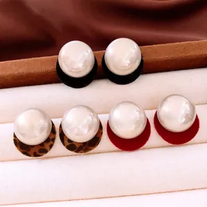 Three pairs of pearl stud earrings with black, leopard, and red plush round pendants