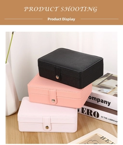 Three-tier stack of portable faux leather jewelry cases in black and pink with metal snap closure