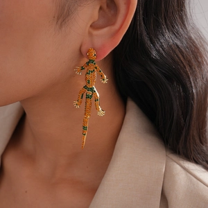 Detailed view of long gecko drop earrings with vibrant orange and green rhinestones