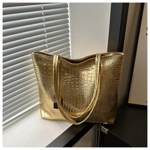 Detailed view of crocodile pattern texture on a golden high-capacity tote bag