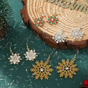 Close-up of five pairs of Christmas snowflake earrings with rhinestones on festive decor