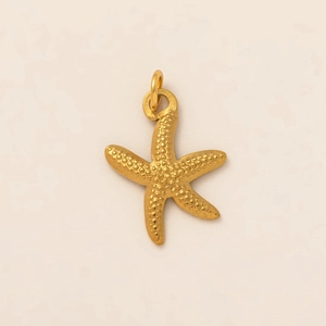 Detailed close-up of a 18K gold starfish pendant featuring unique granular surface texture