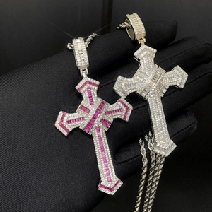 Close-up of hip hop cross pendants with silver metal, pink and clear zircons on twist chains