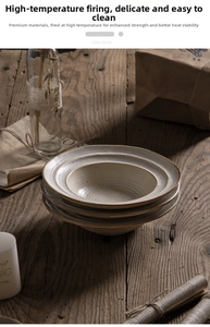 Detail of stacked rustic stoneware ceramic plates on a vintage wooden tabletop