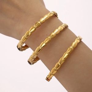 Three stacked 18K gold plated stainless steel bracelets with geometric scale design