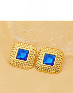 Detail of vintage square gold stud earrings with royal blue stone and beaded texture