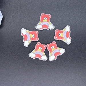 Close-up of five cute resin charms featuring red cartoon bears standing on rainbows and clouds