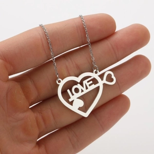 Dettaglio del ciondolo a cuore cavo con scritta LOVE su una catena in argento chic